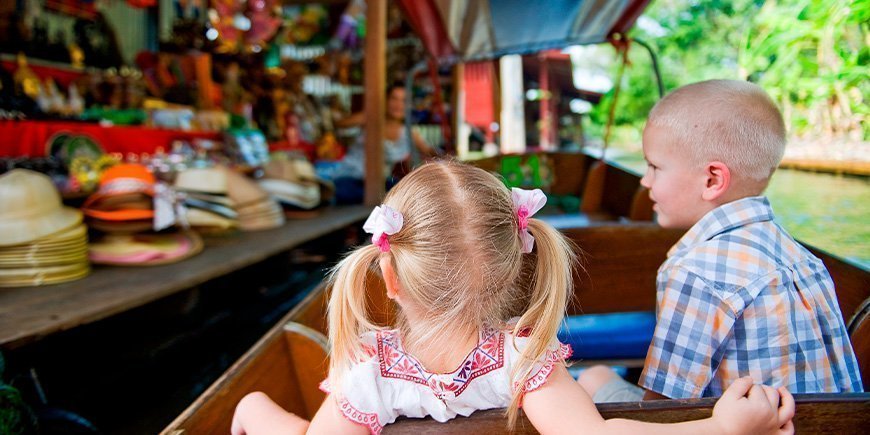 Kinder in einem Boot auf dem Damnoen Saduak Markt in Thailand