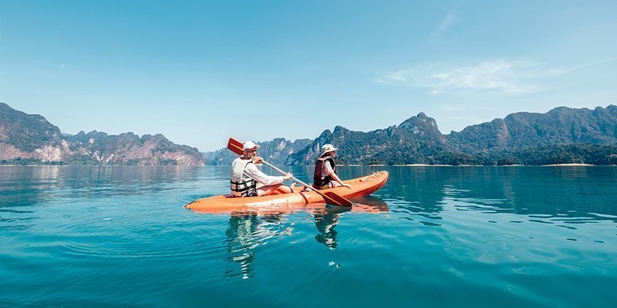 Vater und Sohn beim Kajakfahren auf dem See im Khao Sok National Park