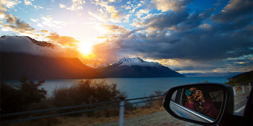 Mann fotografiert aus dem Fenster am Lake Wakatipu auf der Südinsel Neuseelands